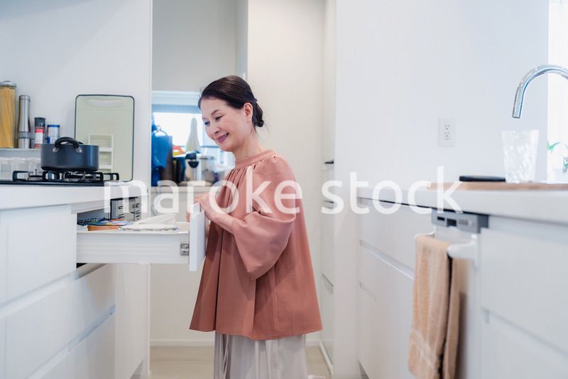 キッチンの収納を工夫するシニアの女性