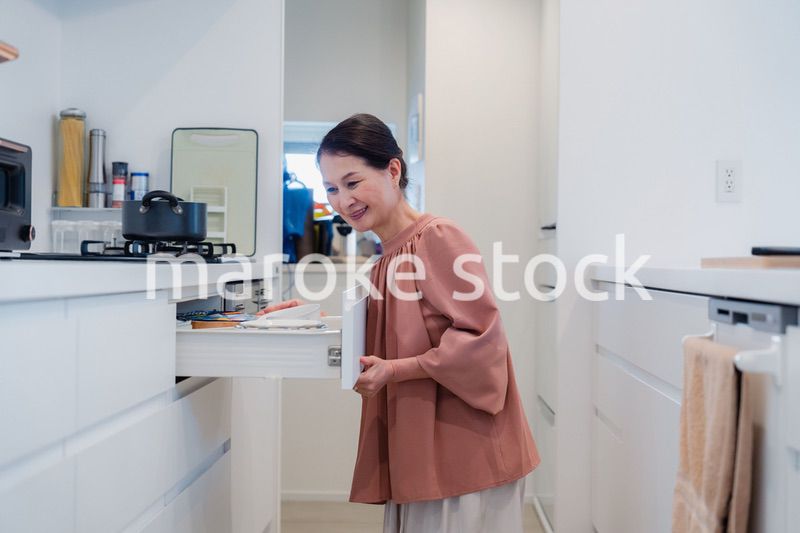 キッチンの収納を工夫するシニアの女性