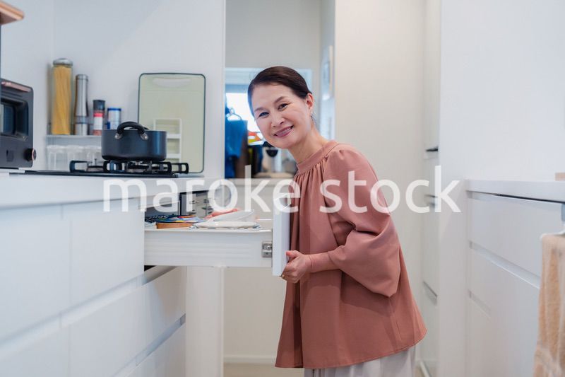 キッチンの収納を工夫するシニアの女性