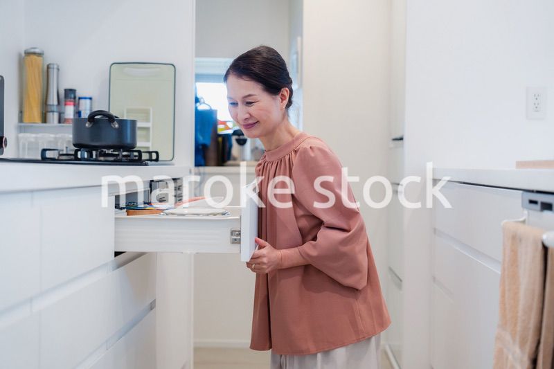キッチンの収納を工夫するシニアの女性