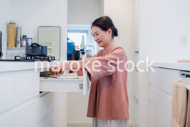 キッチンの収納を工夫するシニアの女性