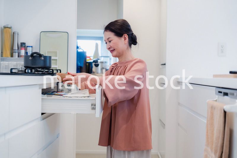 キッチンの収納を工夫するシニアの女性