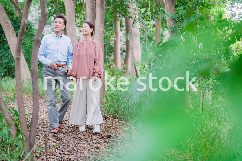 自然の中を散歩するシニアの夫婦