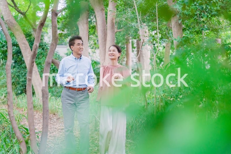 自然の中を散歩するシニアの夫婦
