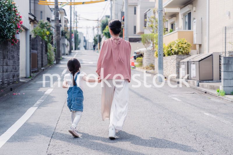 おばあちゃんと街を散歩する女の子