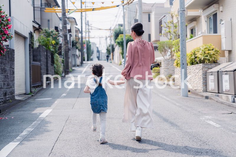 おばあちゃんと街を散歩する女の子