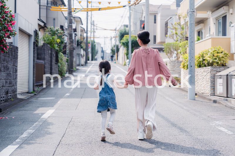 おばあちゃんと街を散歩する女の子