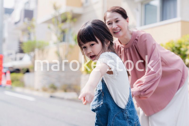 おばあちゃんと街を散歩する女の子