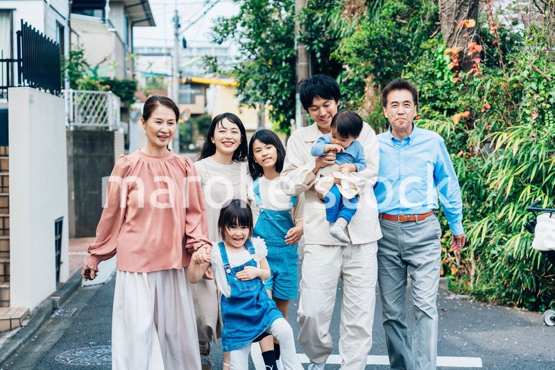笑顔で外を散歩する3世代のファミリー