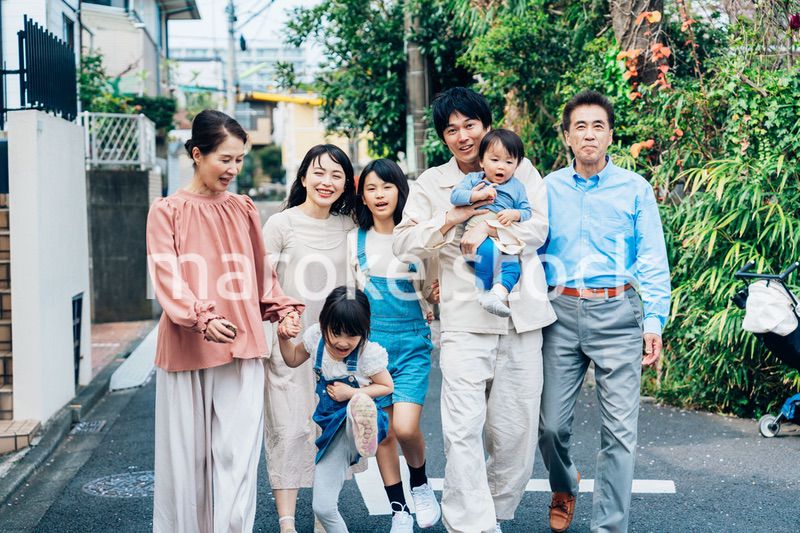 笑顔で外を散歩する3世代のファミリー