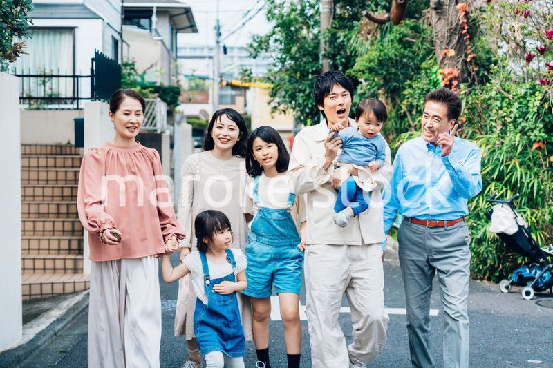 笑顔で外を散歩する3世代のファミリー