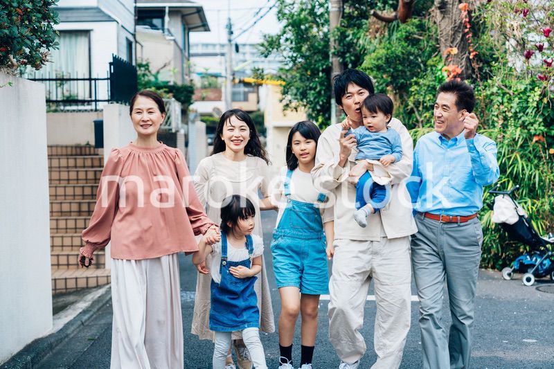 笑顔で外を散歩する3世代のファミリー