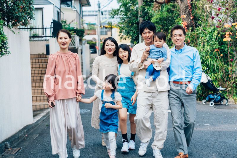 笑顔で外を散歩する3世代のファミリー