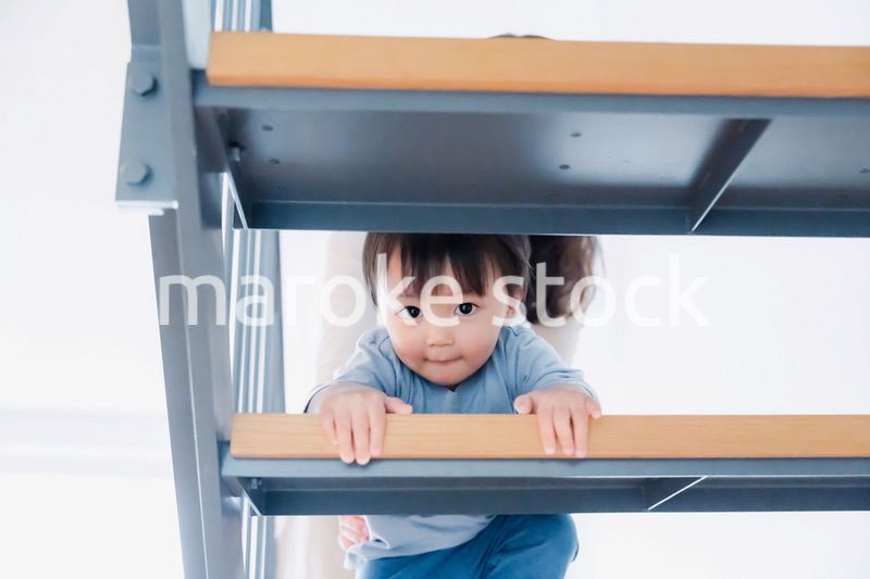 家の階段をハイハイで登る1歳の男の子