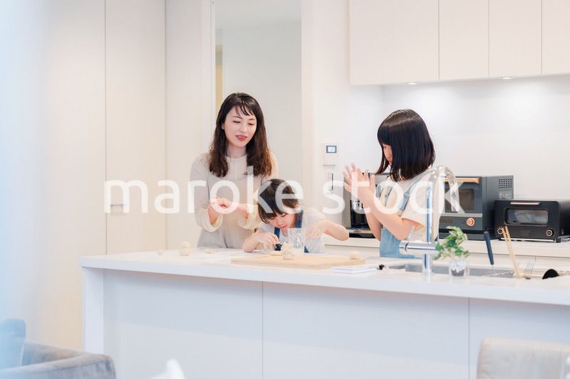 お母さんと一緒に料理をする子どもたち