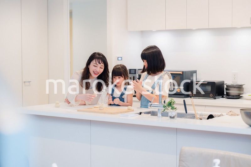 お母さんと一緒に料理をする子どもたち