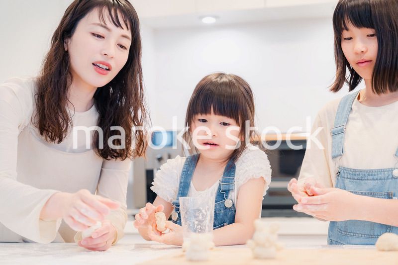 お母さんと一緒に料理をする子どもたち