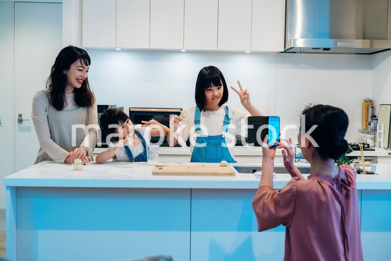 スマホで孫たちの写真を撮るおばあちゃん