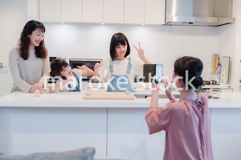 スマホで孫たちの写真を撮るおばあちゃん