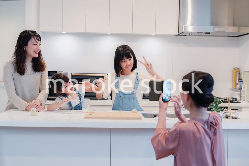 スマホで孫たちの写真を撮るおばあちゃん