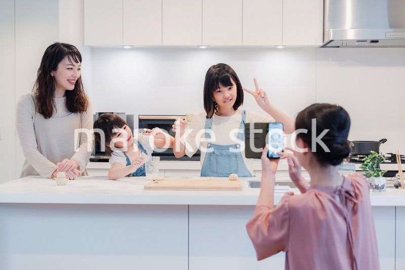 スマホで孫たちの写真を撮るおばあちゃん