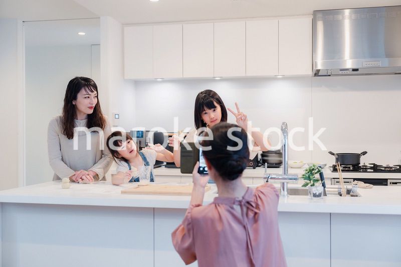 スマホで孫たちの写真を撮るおばあちゃん