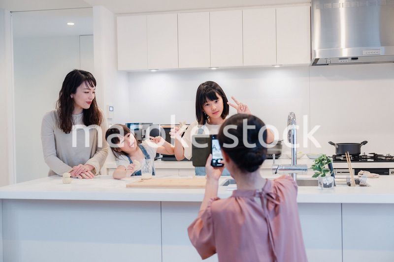 スマホで孫たちの写真を撮るおばあちゃん