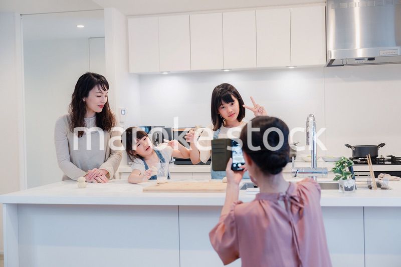 スマホで孫たちの写真を撮るおばあちゃん