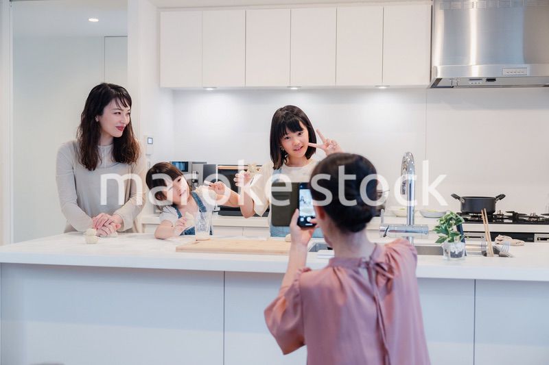 スマホで孫たちの写真を撮るおばあちゃん