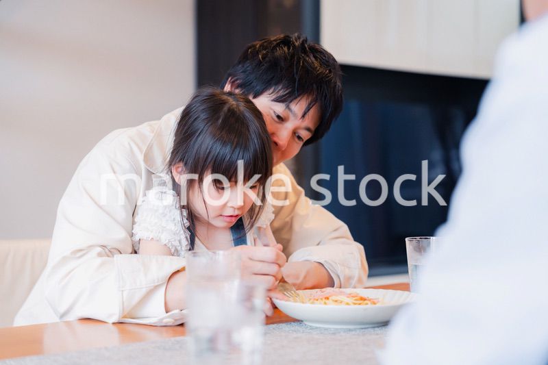 パパと一緒にご飯を食べる小さな女の子
