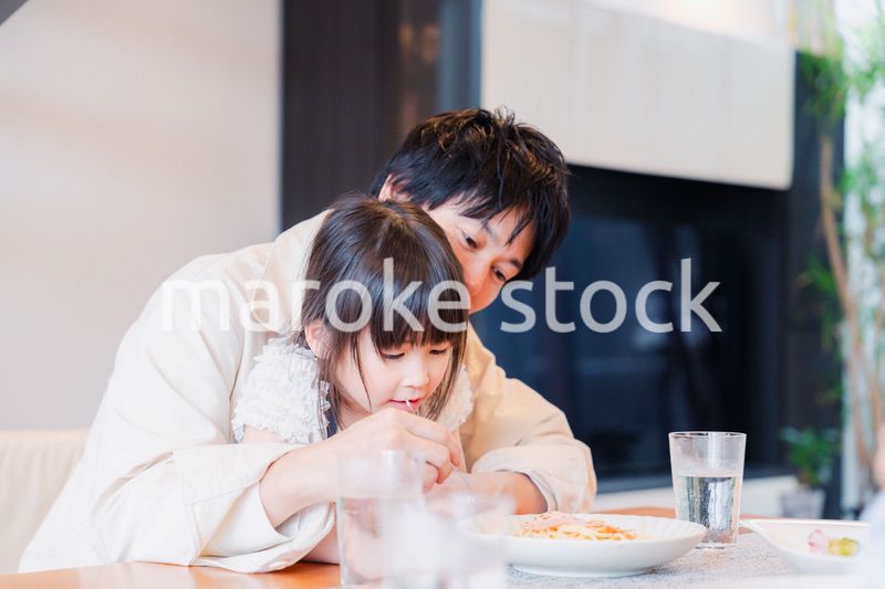 パパと一緒にご飯を食べる小さな女の子