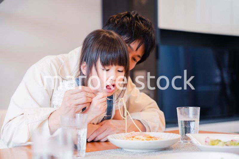 パパと一緒にご飯を食べる小さな女の子