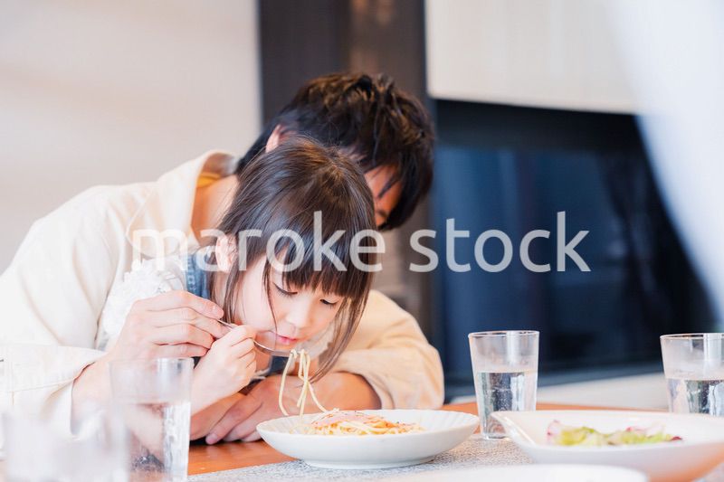 パパと一緒にご飯を食べる小さな女の子