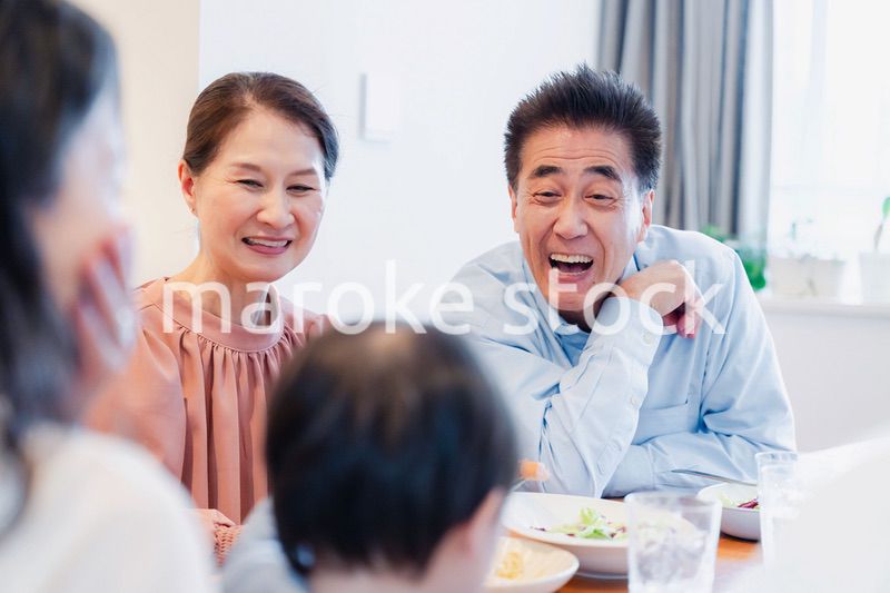 孫たちと一緒に楽しくごはんを食べる高齢の夫婦