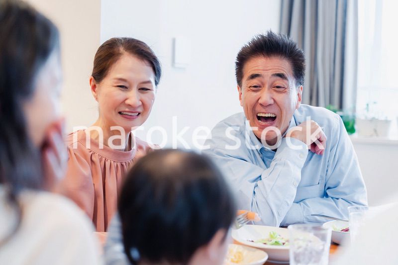 孫たちと一緒に楽しくごはんを食べる高齢の夫婦