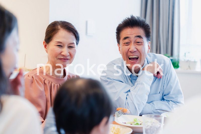 孫たちと一緒に楽しくごはんを食べる高齢の夫婦