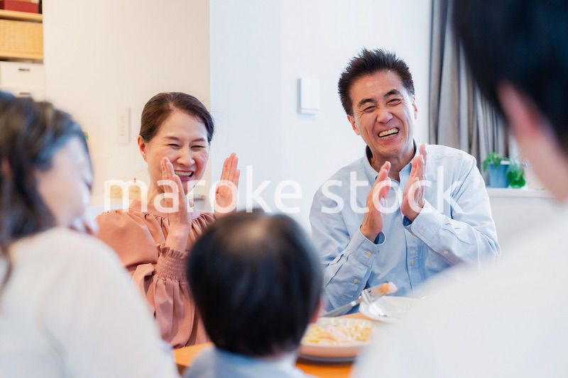 孫たちと一緒に楽しくごはんを食べる高齢の夫婦