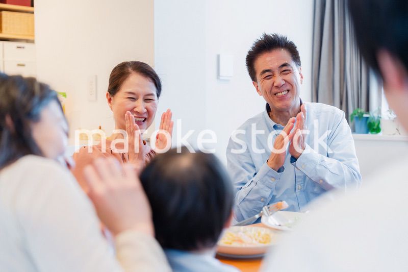 孫たちと一緒に楽しくごはんを食べる高齢の夫婦