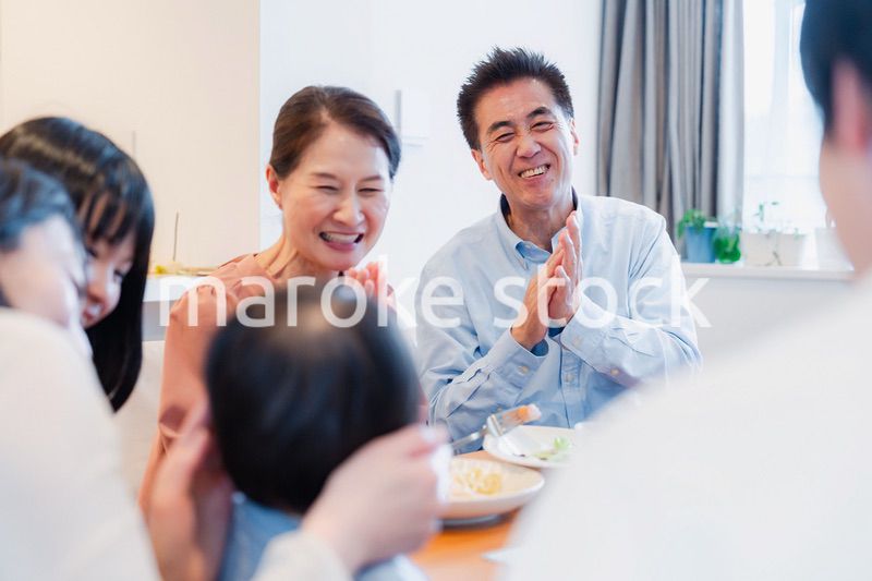 孫たちと一緒に楽しくごはんを食べる高齢の夫婦