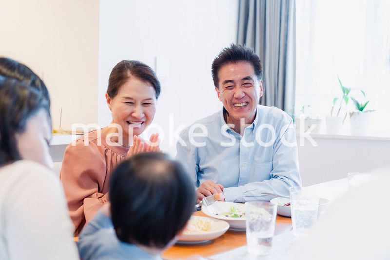 孫たちと一緒に楽しくごはんを食べる高齢の夫婦