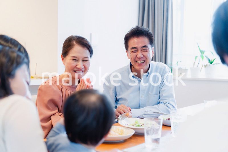 孫たちと一緒に楽しくごはんを食べる高齢の夫婦