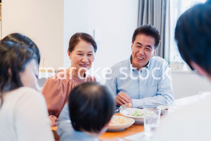 孫たちと一緒に楽しくごはんを食べる高齢の夫婦