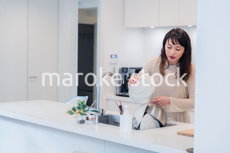 キッチンで忙しく家事をする主婦
