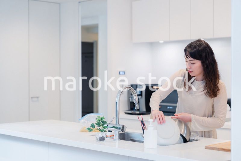 キッチンで忙しく家事をする主婦