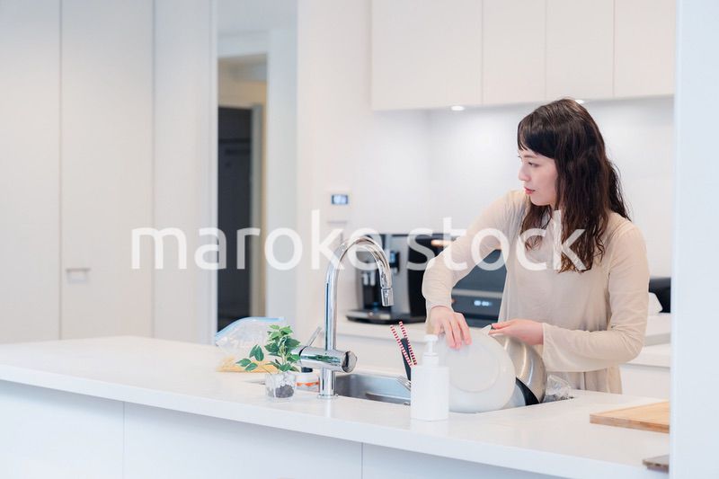 キッチンで忙しく家事をする主婦