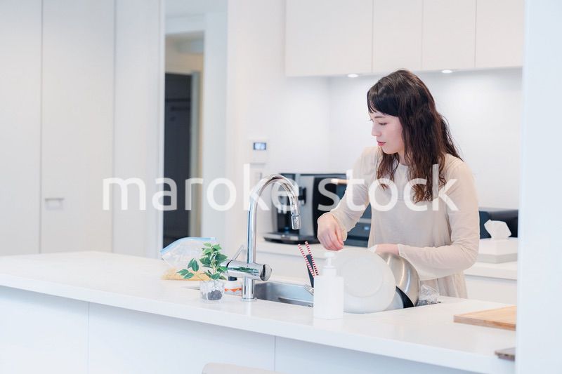 キッチンで忙しく家事をする主婦
