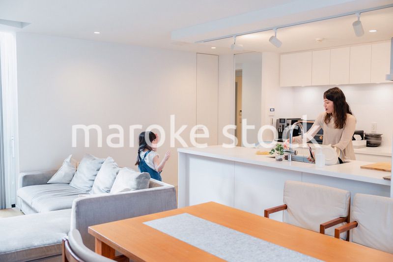 キッチンで家事をしながら子供と会話をするお母さん