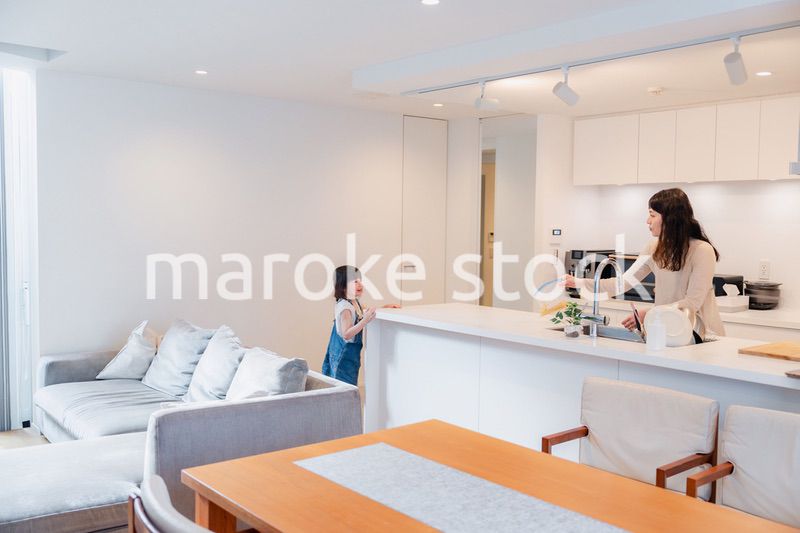 キッチンで家事をしながら子供と会話をするお母さん