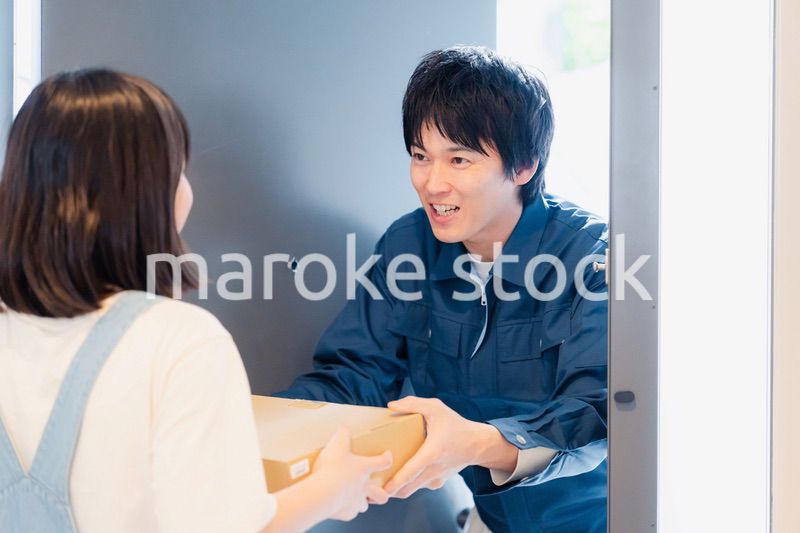 笑顔で宅配便の配達をする若い男性