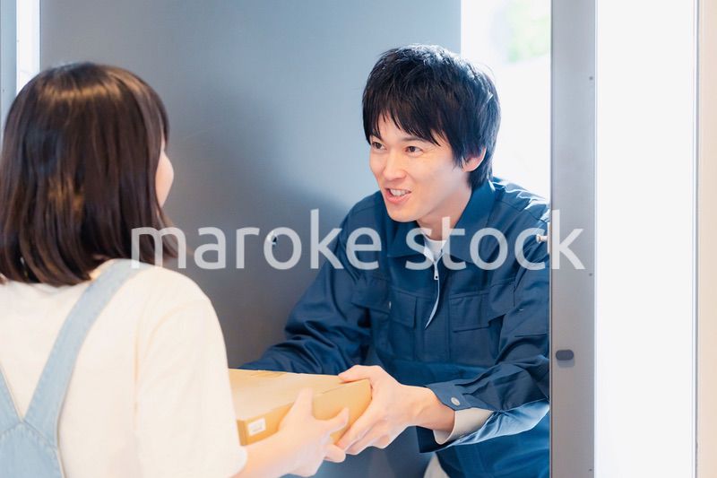 笑顔で宅配便の配達をする若い男性